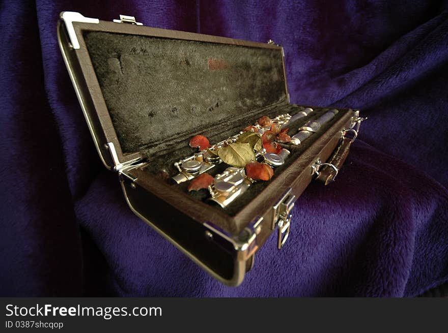 A side flute in wooden case with a rose. A side flute in wooden case with a rose.