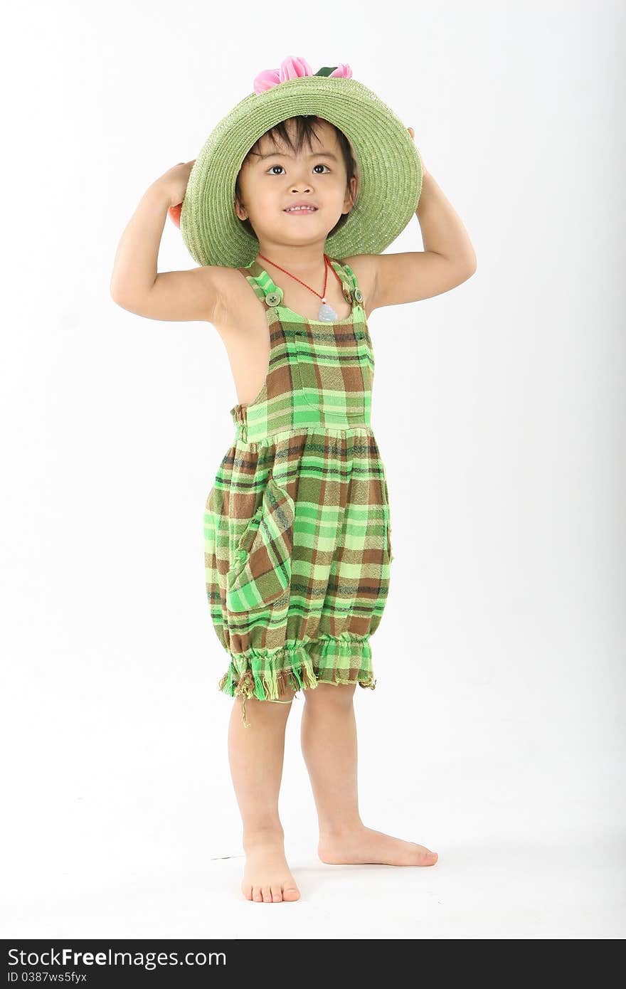 The girl standing with a green hat and wearing green grid clothes. The girl standing with a green hat and wearing green grid clothes.