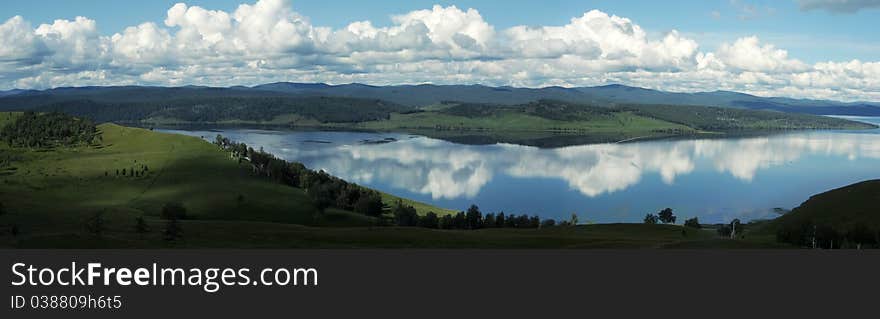 Green field and lake in summer