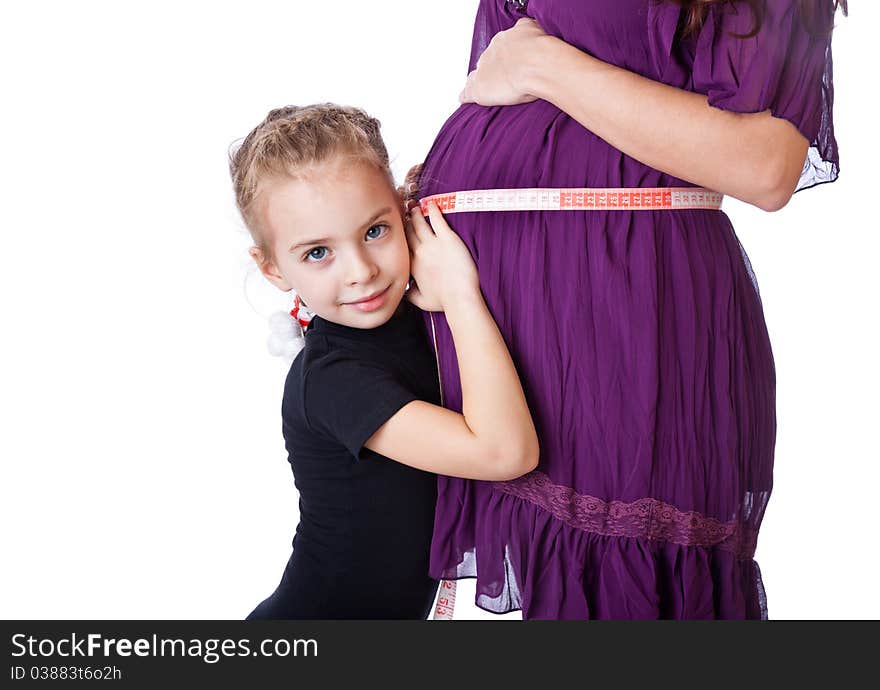 A girl measures the belly of her mother