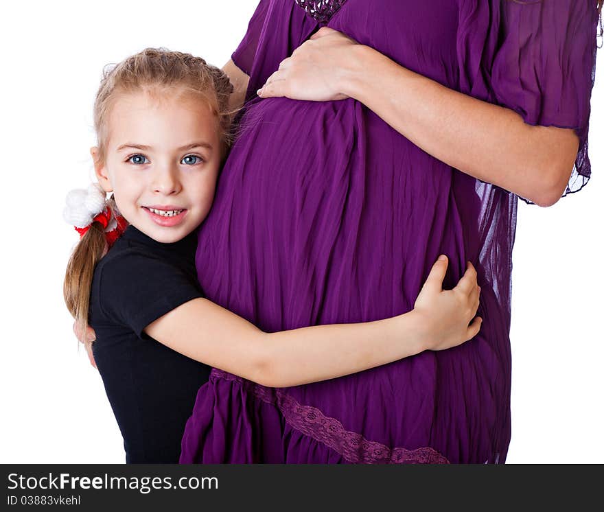 A girl is listening to the abdomen of her mother