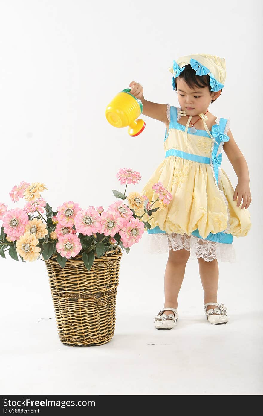 Little girl  with a sprinkler is  watering flowers just as a gardener ã€‚. Little girl  with a sprinkler is  watering flowers just as a gardener ã€‚