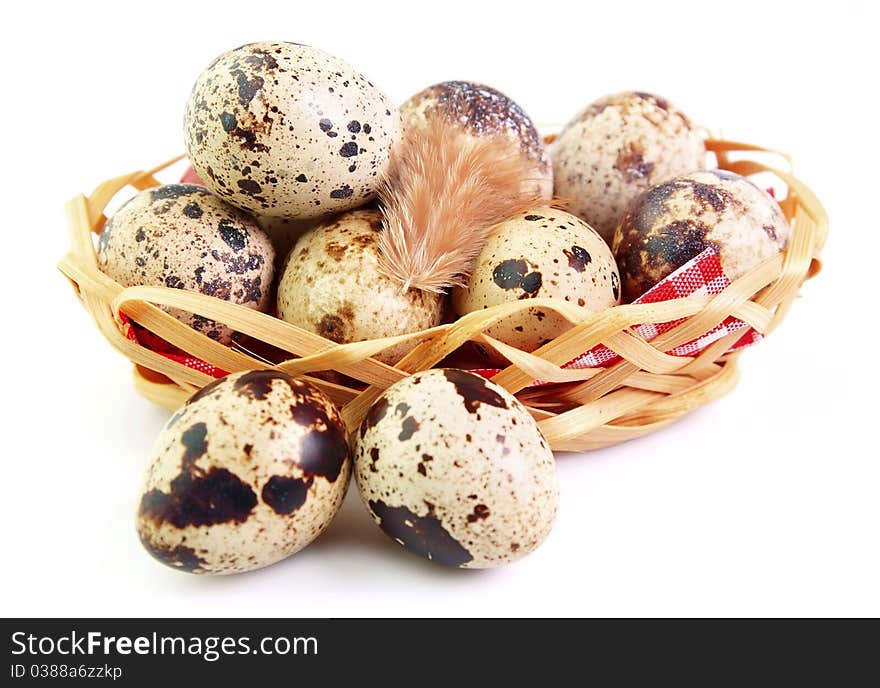 Quail eggs in a basket with a feather