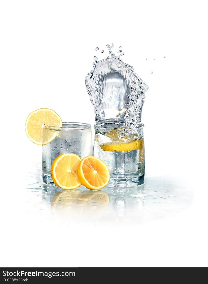 Two glasses of splashing water with ice and lemon. Isolated on white with clipping path. Two glasses of splashing water with ice and lemon. Isolated on white with clipping path