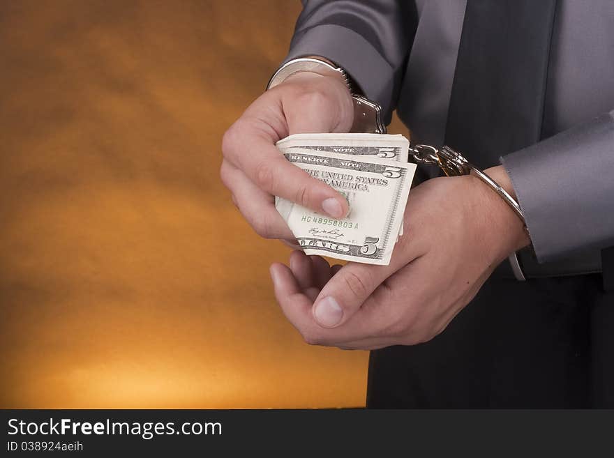 Arrest, close-up man's hands with money in handcuffs. Arrest, close-up man's hands with money in handcuffs.