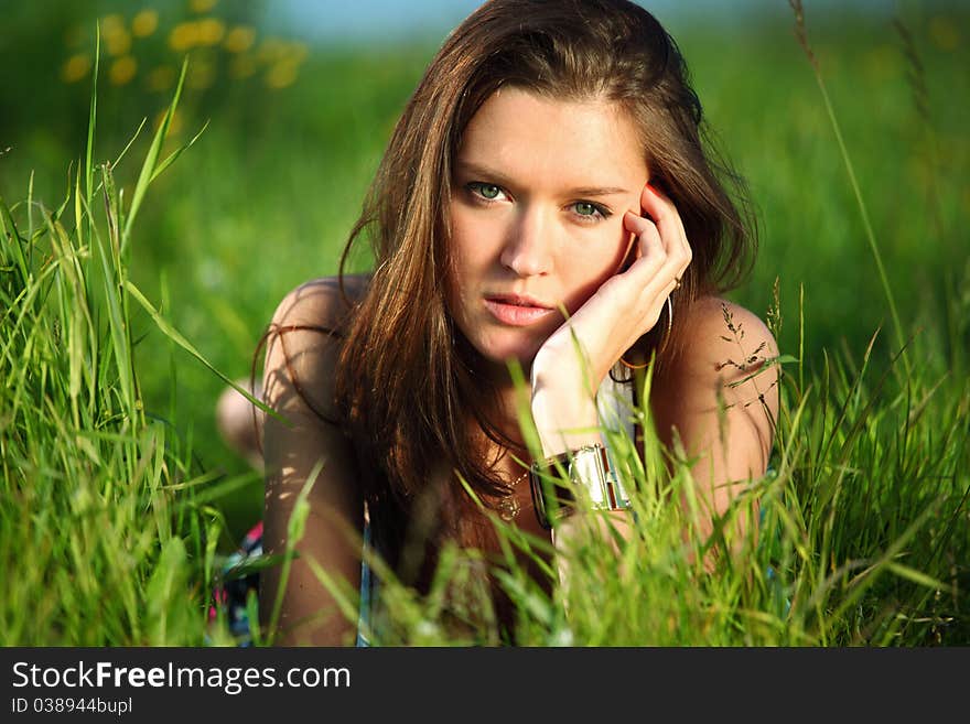 Brunette lays on green grass. Brunette lays on green grass