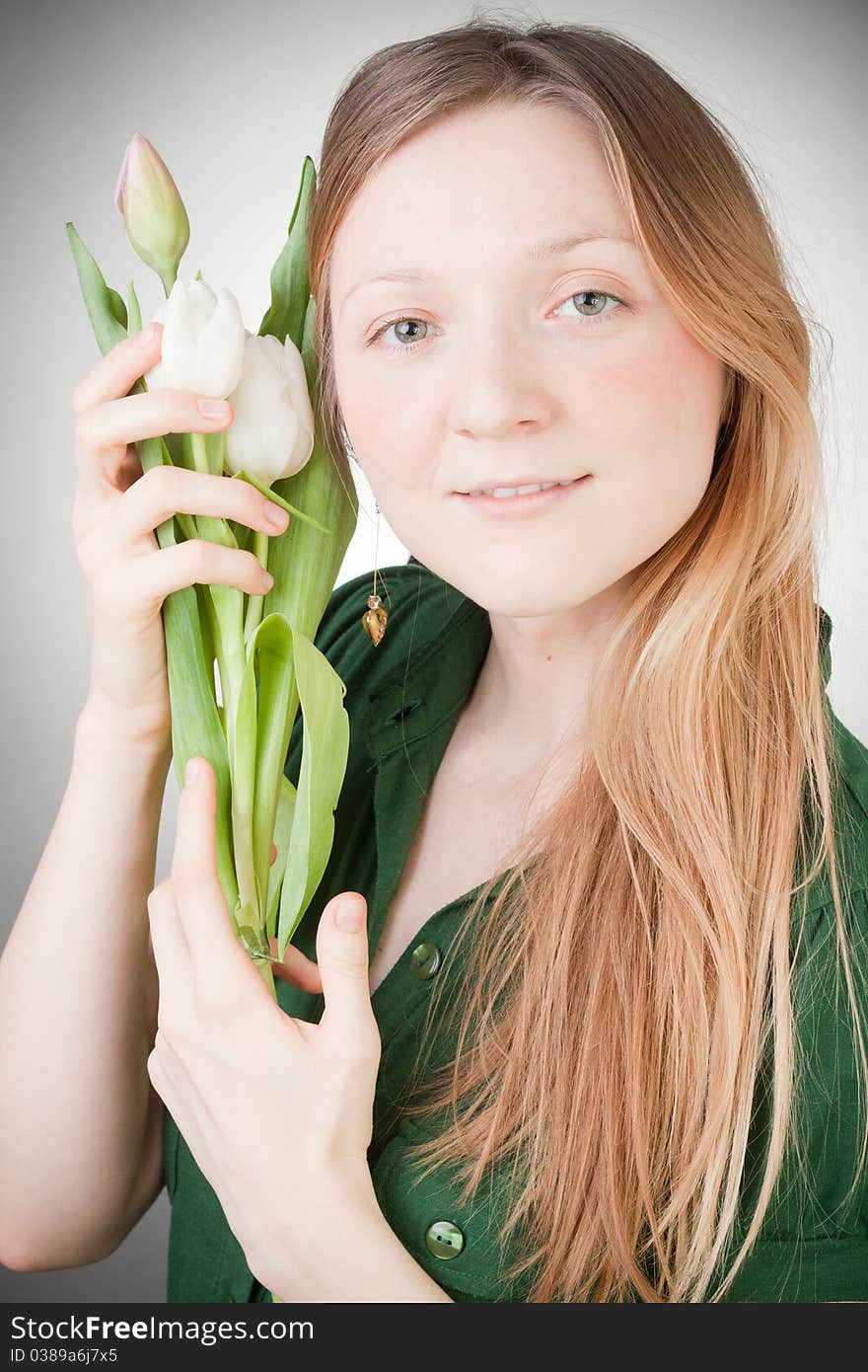 Young girl with tulips, with grey background. Young girl with tulips, with grey background