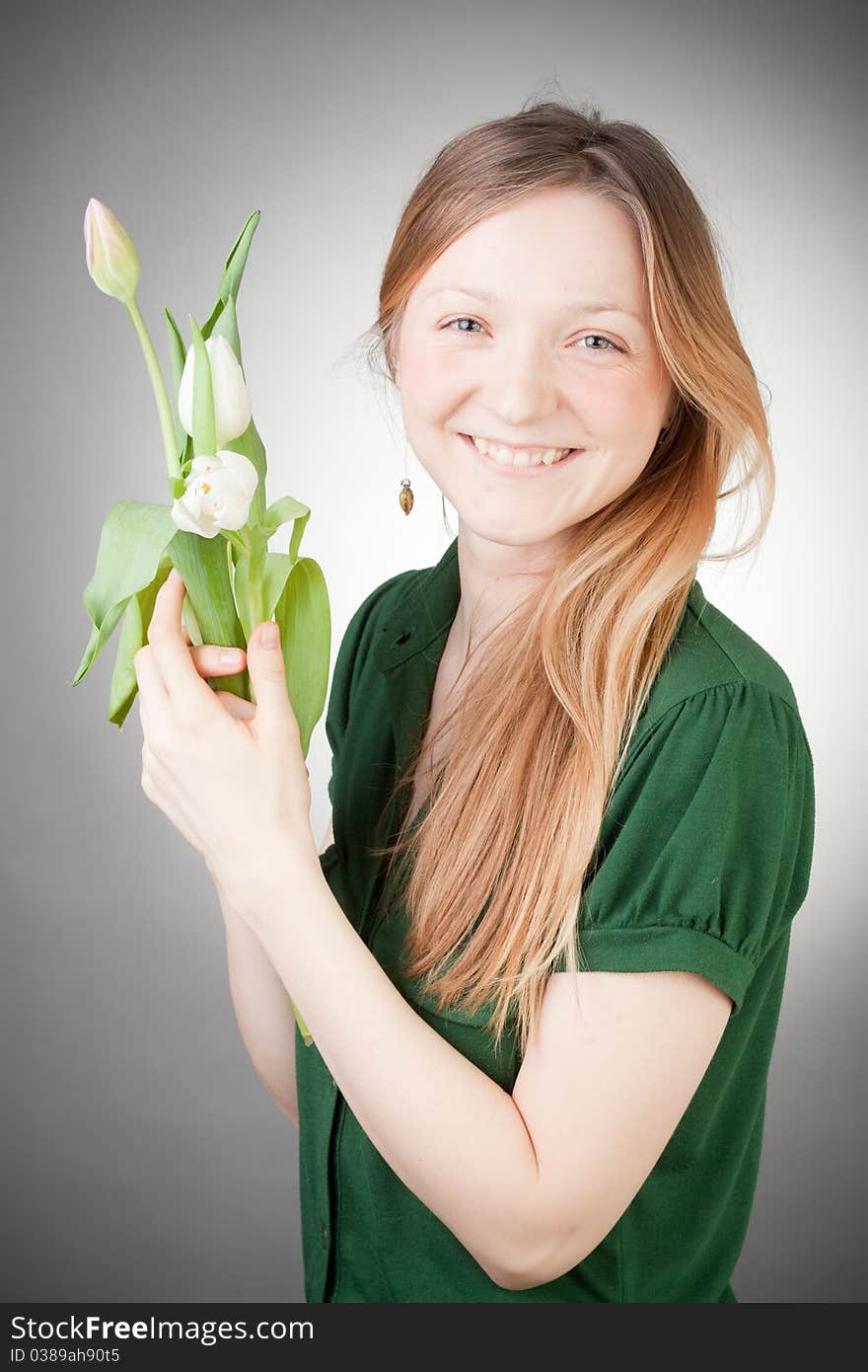 Young girl with tulips, with grey background. Young girl with tulips, with grey background