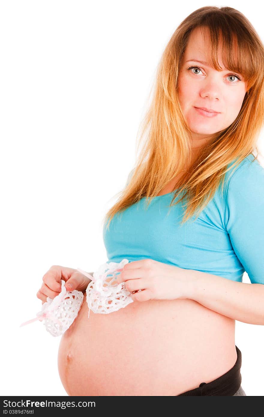 Beautiful pregnant woman with baby's bootees on white background