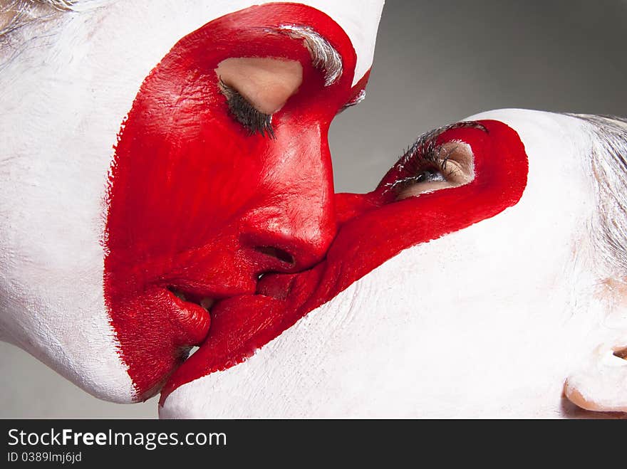 Two girls with painted faces delivering red heart pattern. Two girls with painted faces delivering red heart pattern