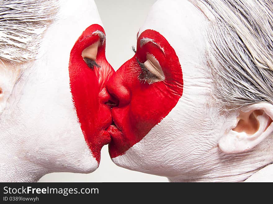 Two girls with painted faces delivering red heart pattern. Two girls with painted faces delivering red heart pattern