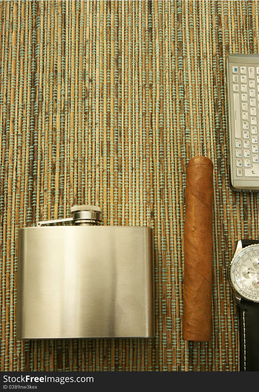 Close up of cigar, hip flask, wristwatch and phone. Background. Close up of cigar, hip flask, wristwatch and phone. Background