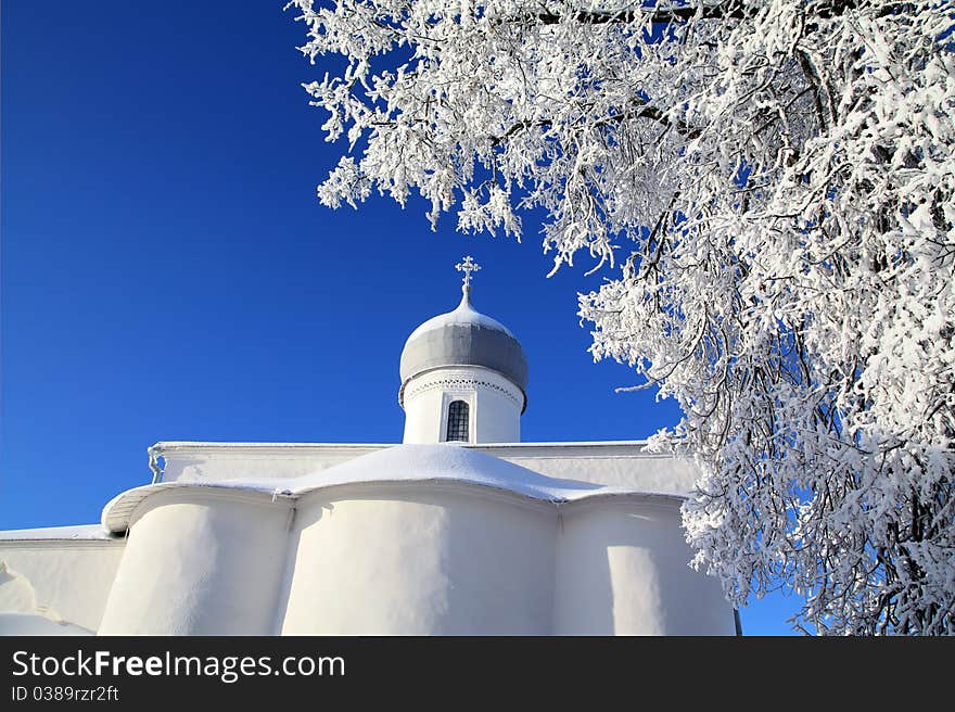 Tree in snow against christian church