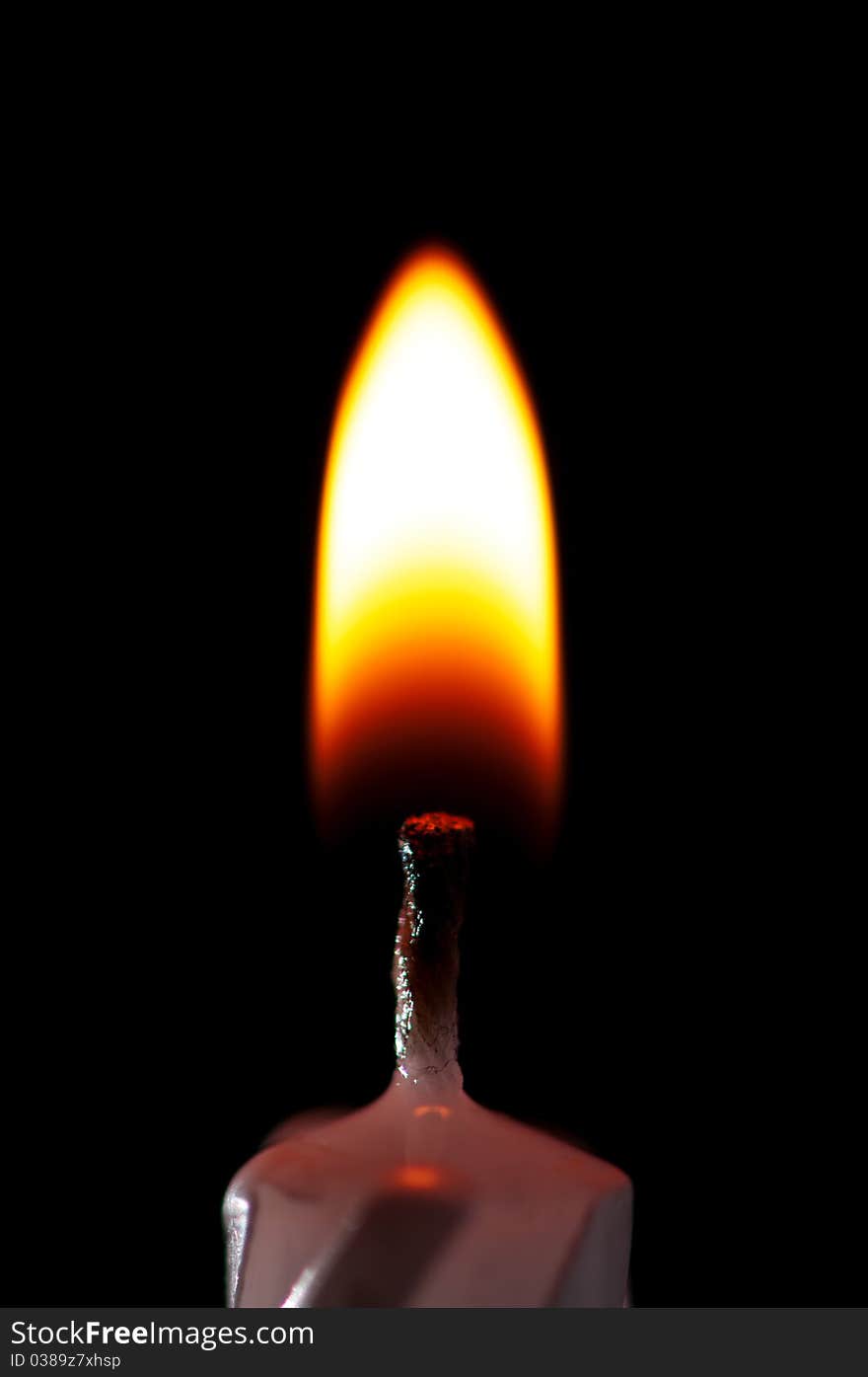 Close-up of burning candle isolated on black background. Close-up of burning candle isolated on black background