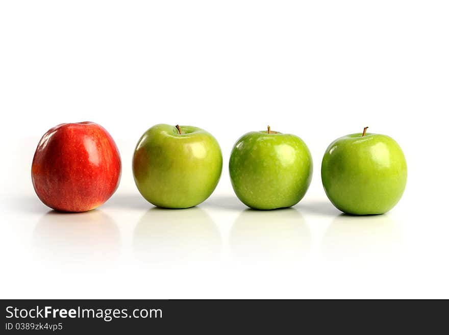 Red apple among green apples isolated on a white background