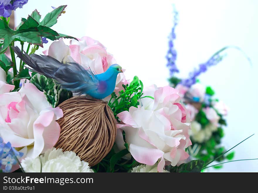 Little bird in artificial flowers.