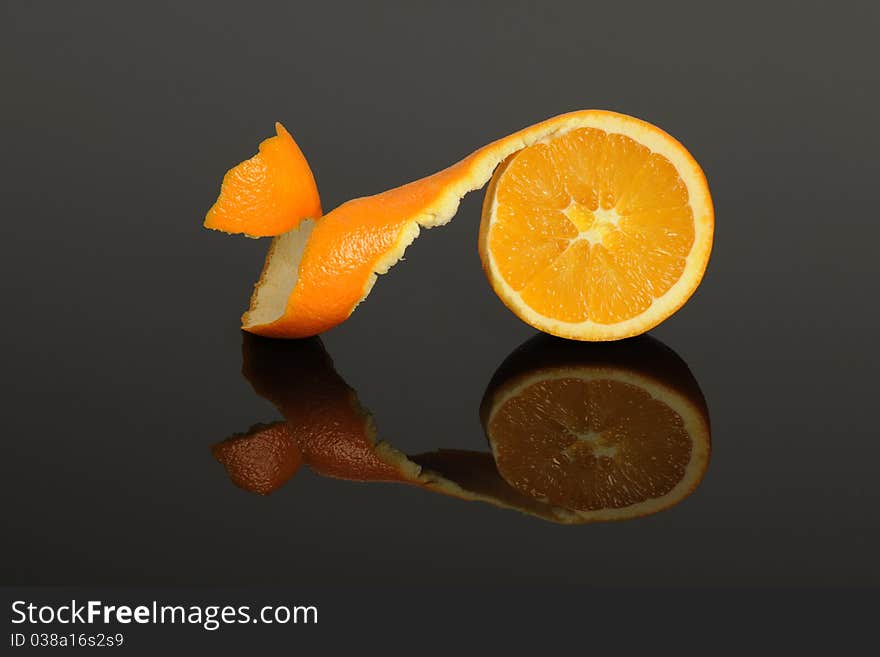 Half Orange peeled isolated on a gray reflective surface