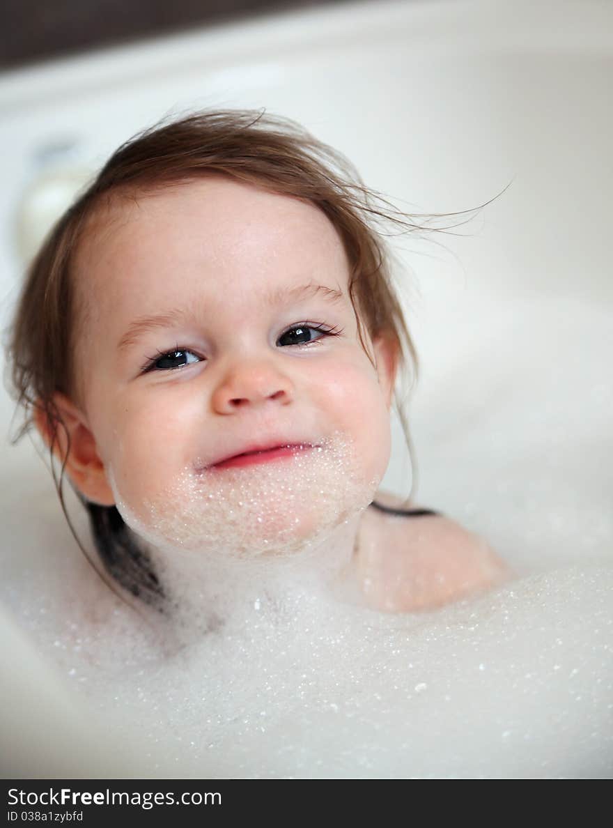 Little toddler girl in a bubble bath with soap on her face. Little toddler girl in a bubble bath with soap on her face