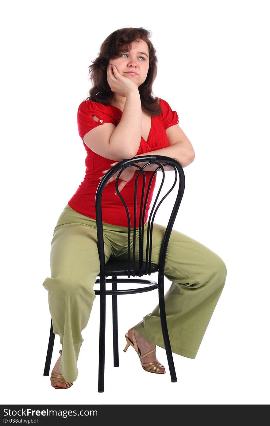 Chubby girl sits on stool dreaming. Isolated on white.