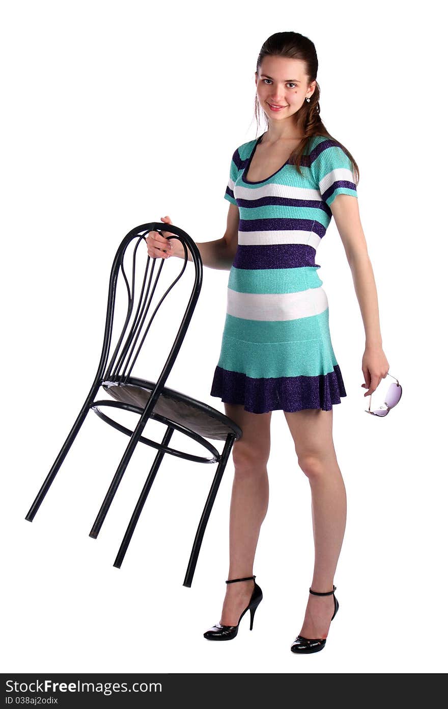 Girl in stripy blue dress holds stool. Isolated on white.