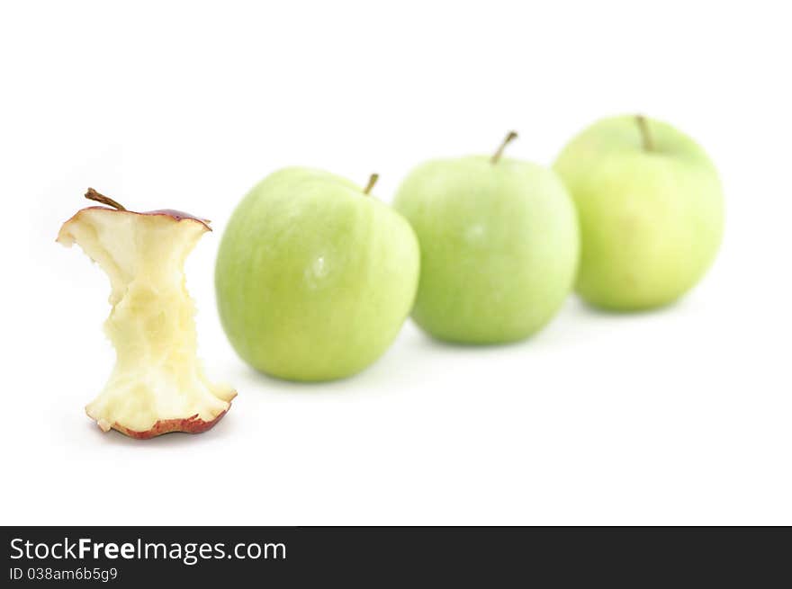 A red apple is singled out and devoured for being different to its green counterparts. Could be used to illustrate a variety of concepts. Isolated on a white background.