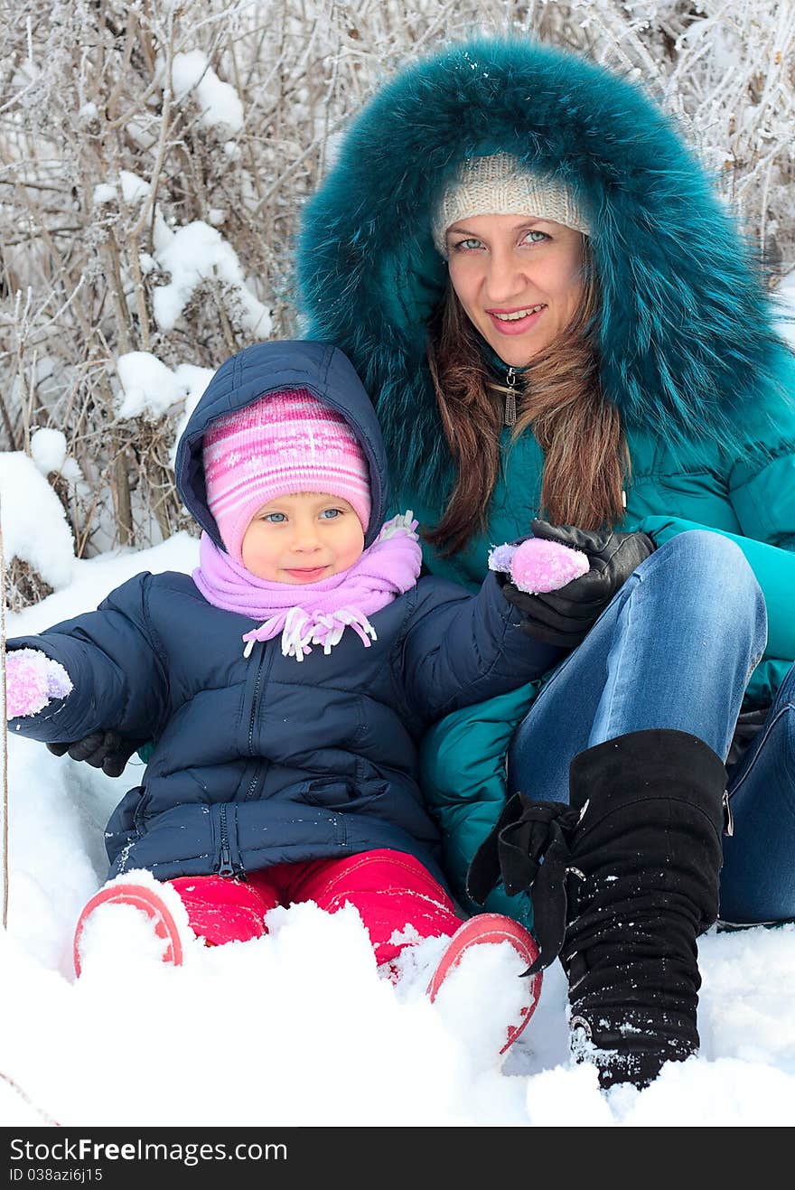 Mother and  kid having fun outdoors on  winter day