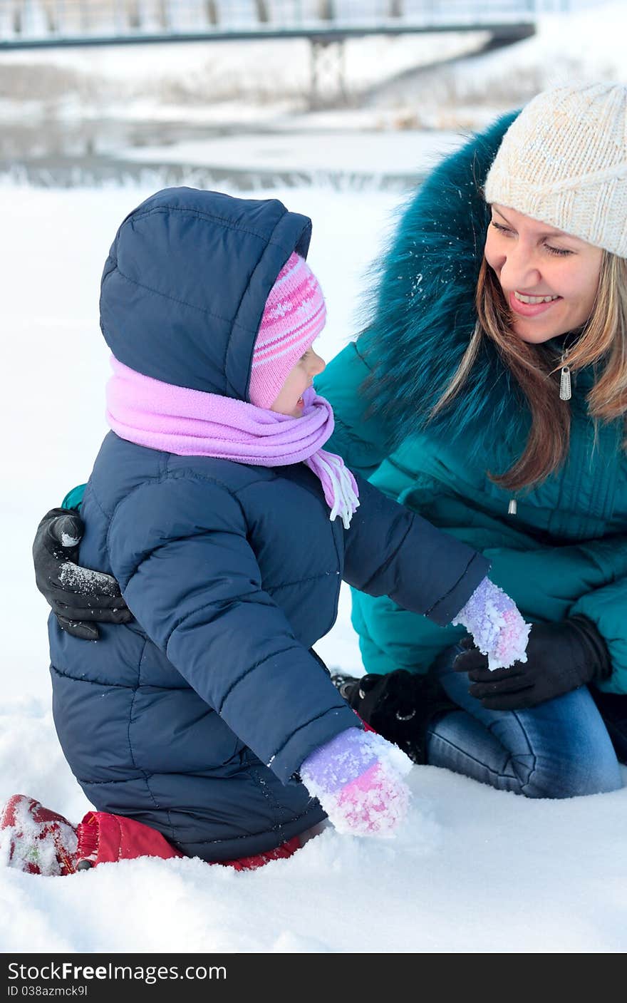 Mother and  kid having fun outdoors on  winter day