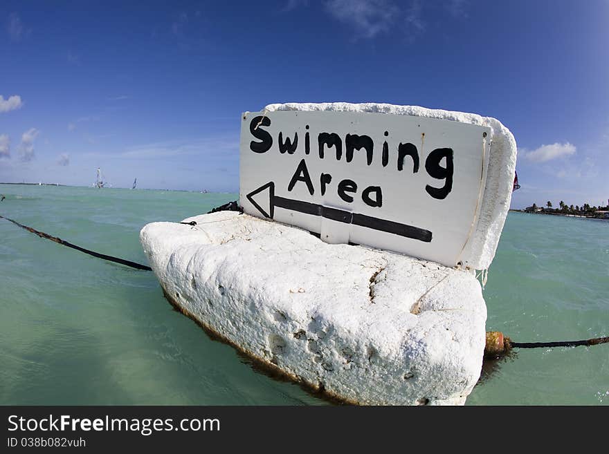 Floating swim sign in tropical bay. Floating swim sign in tropical bay