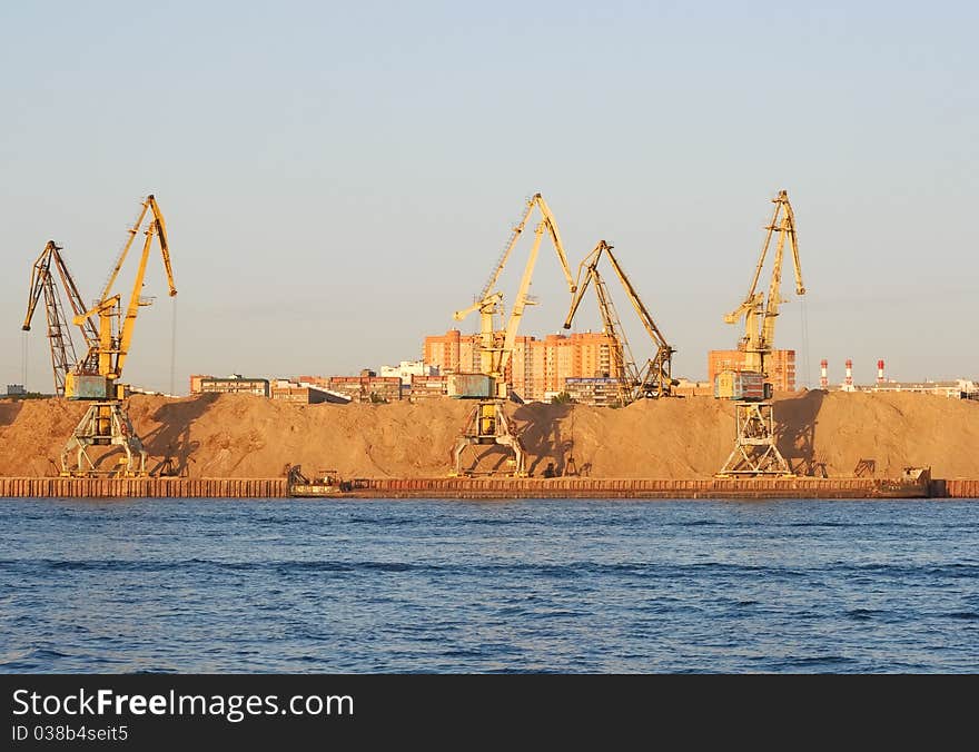 Yellow dock cranes in the river port of Moscow. Photo taken at sunset. Yellow dock cranes in the river port of Moscow. Photo taken at sunset.