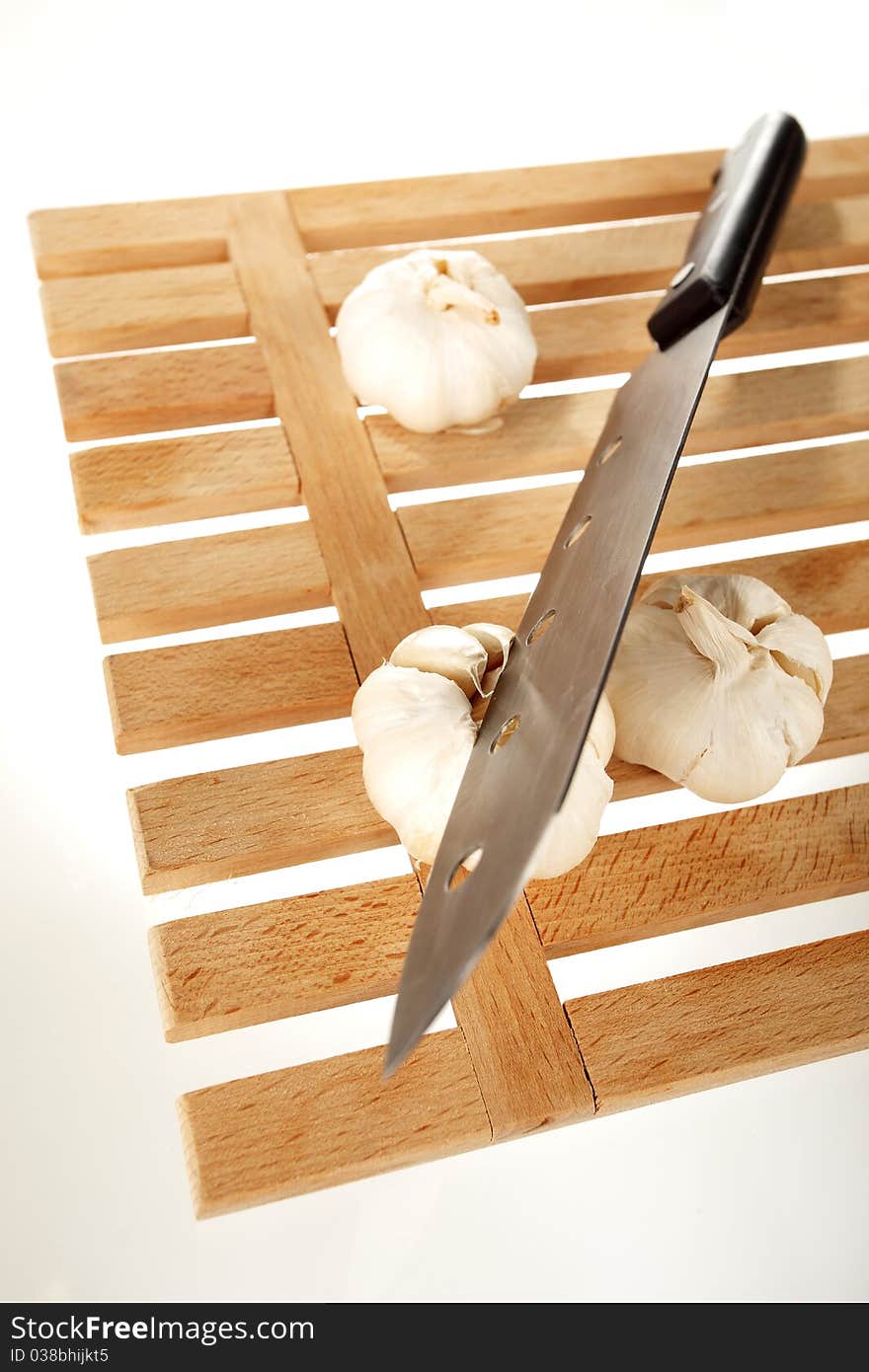 Garlic and knife on a wooden plate