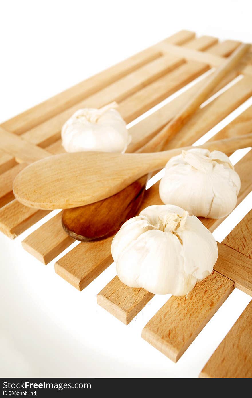 Garlic and ladles on a wooden plate. Garlic and ladles on a wooden plate