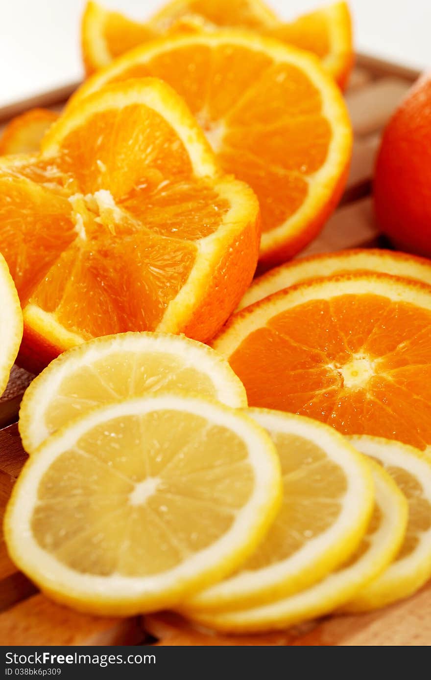 Orange and lemon slices on a wooden plate. Orange and lemon slices on a wooden plate