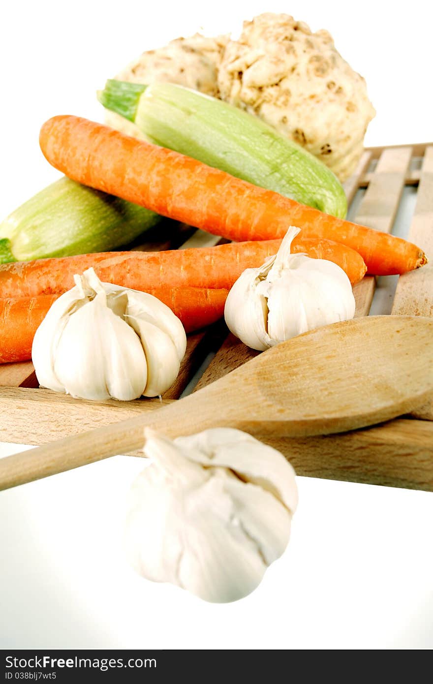 Vegetables on a wooden plate on a white background. Vegetables on a wooden plate on a white background