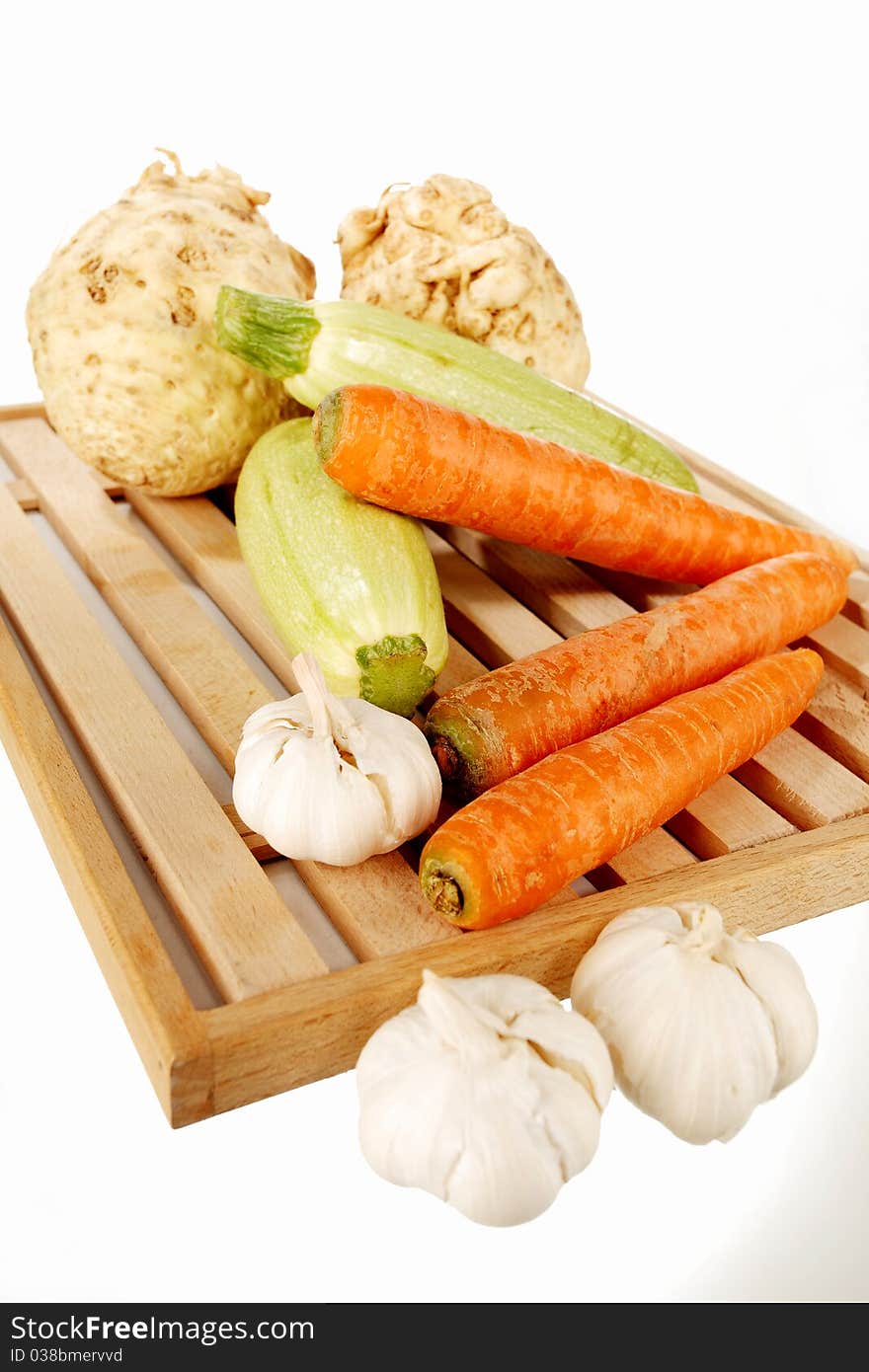 Vegetables on a wooden plate on a white background