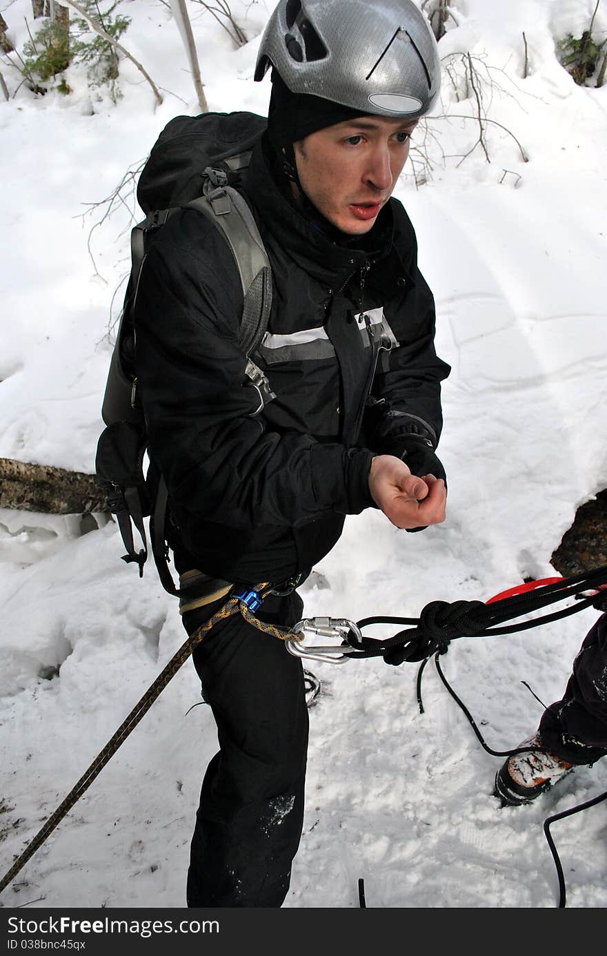 A young climber roped in to repel down a frozen waterfall.