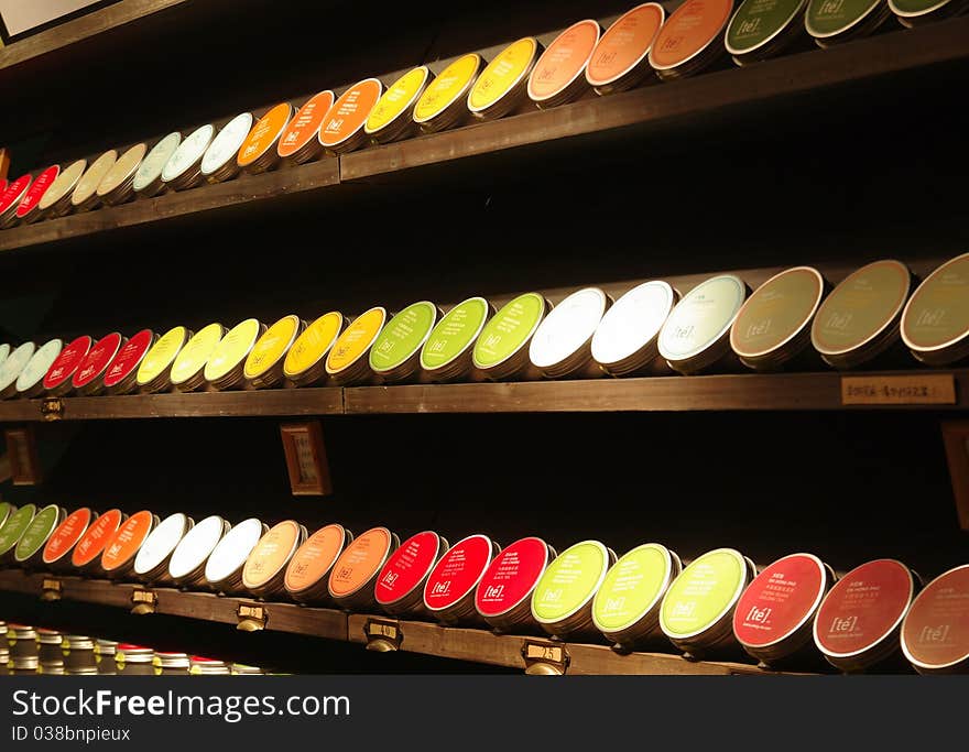 Beautiful tea-cans on wooden shelf