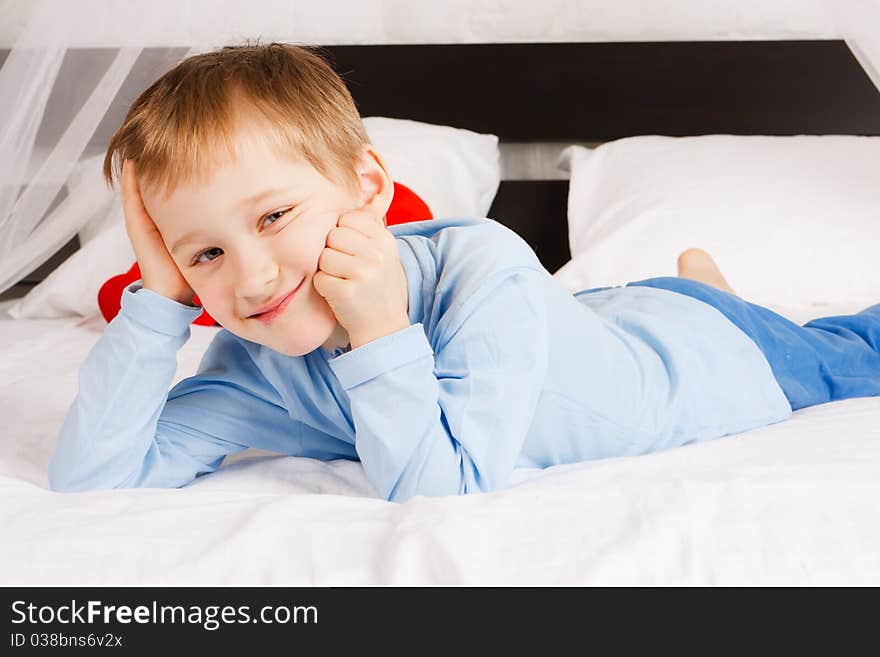 Boy  lies on a bed in a comfortable situation