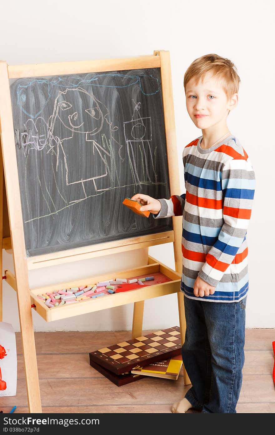 Boy draws a chalk on a board