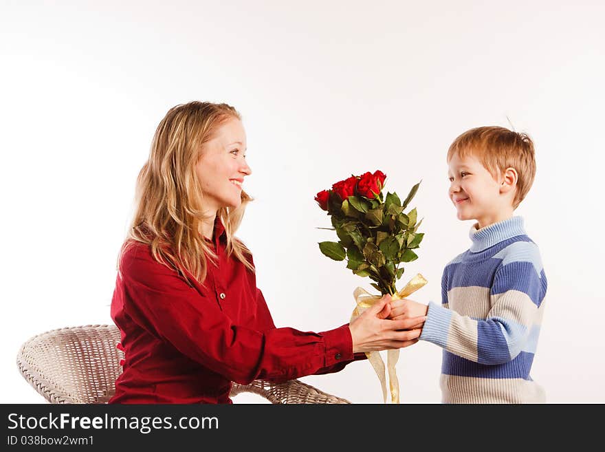 Charming  beautiful young woman with a son and with the bouquet of red roses on a white background