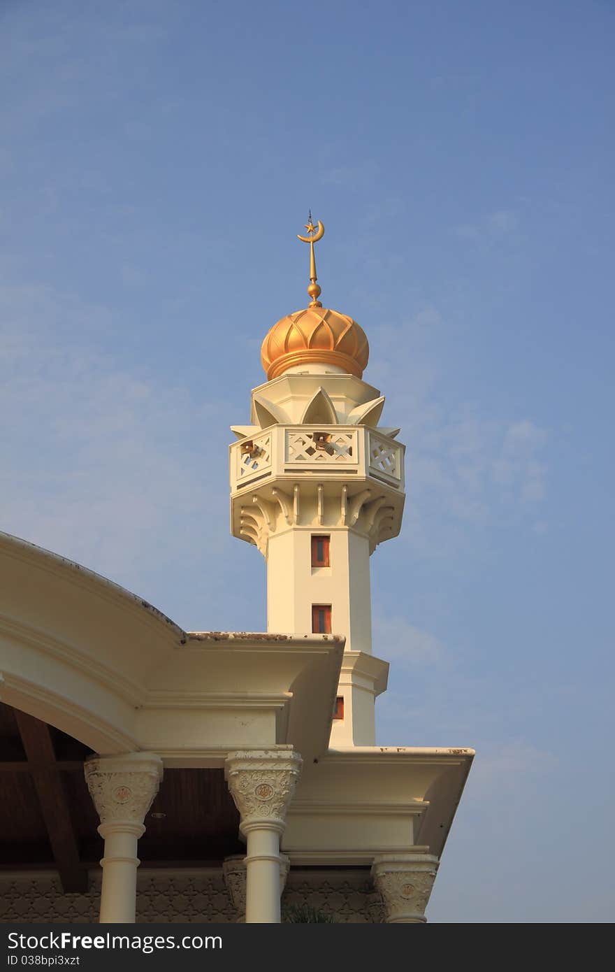 Golden Muslim tower near church