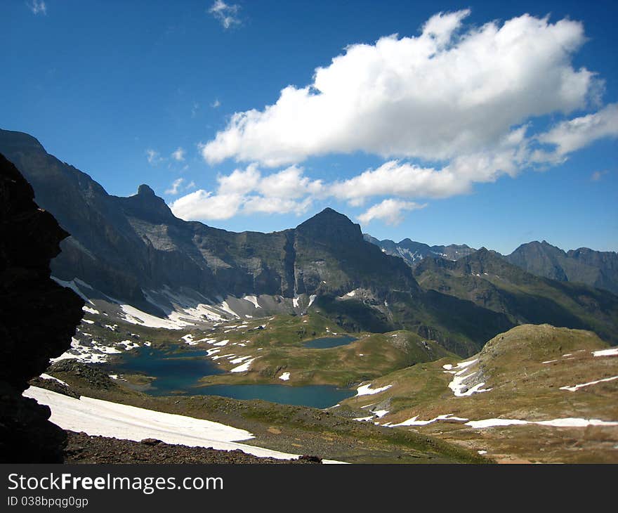 Small lakes and snow surrounded by high rocky mountains