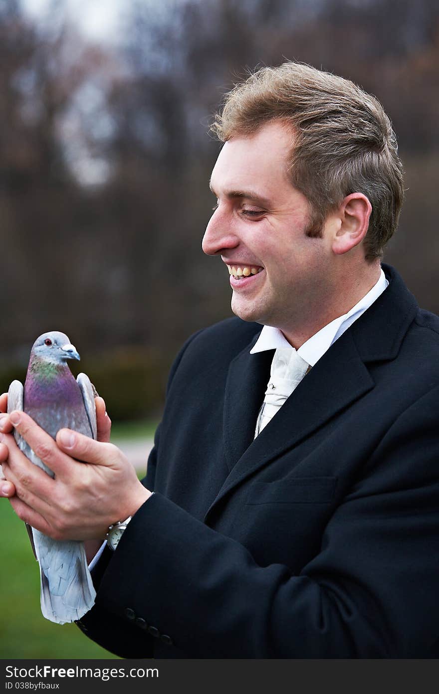 Joyful groom with pigeons on hands