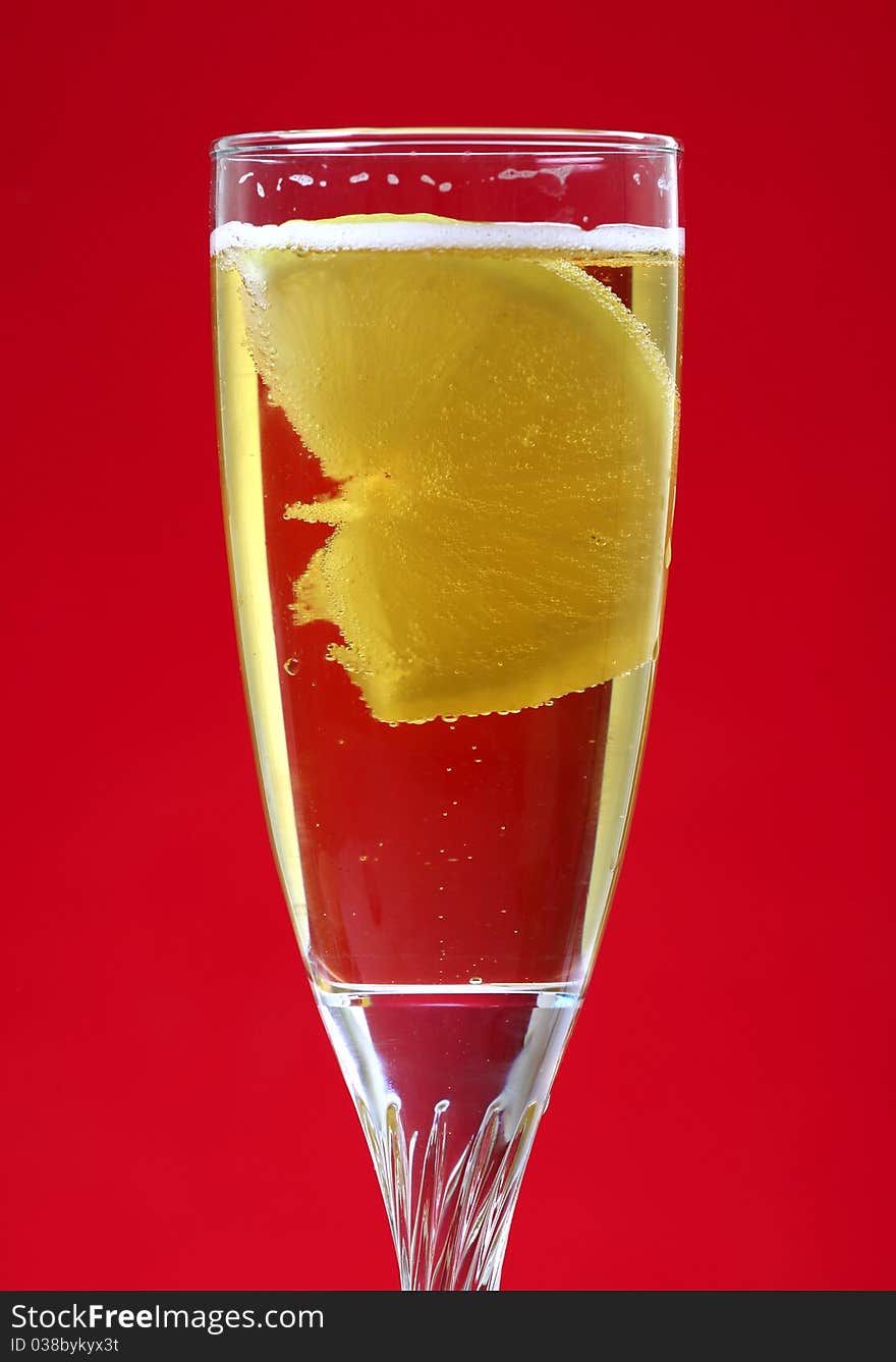 Bubbly lemon drink isolated on red background.