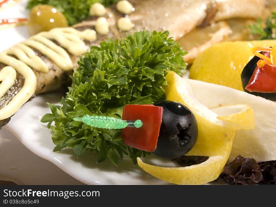 Stuffed baked fish served with lemon and salad