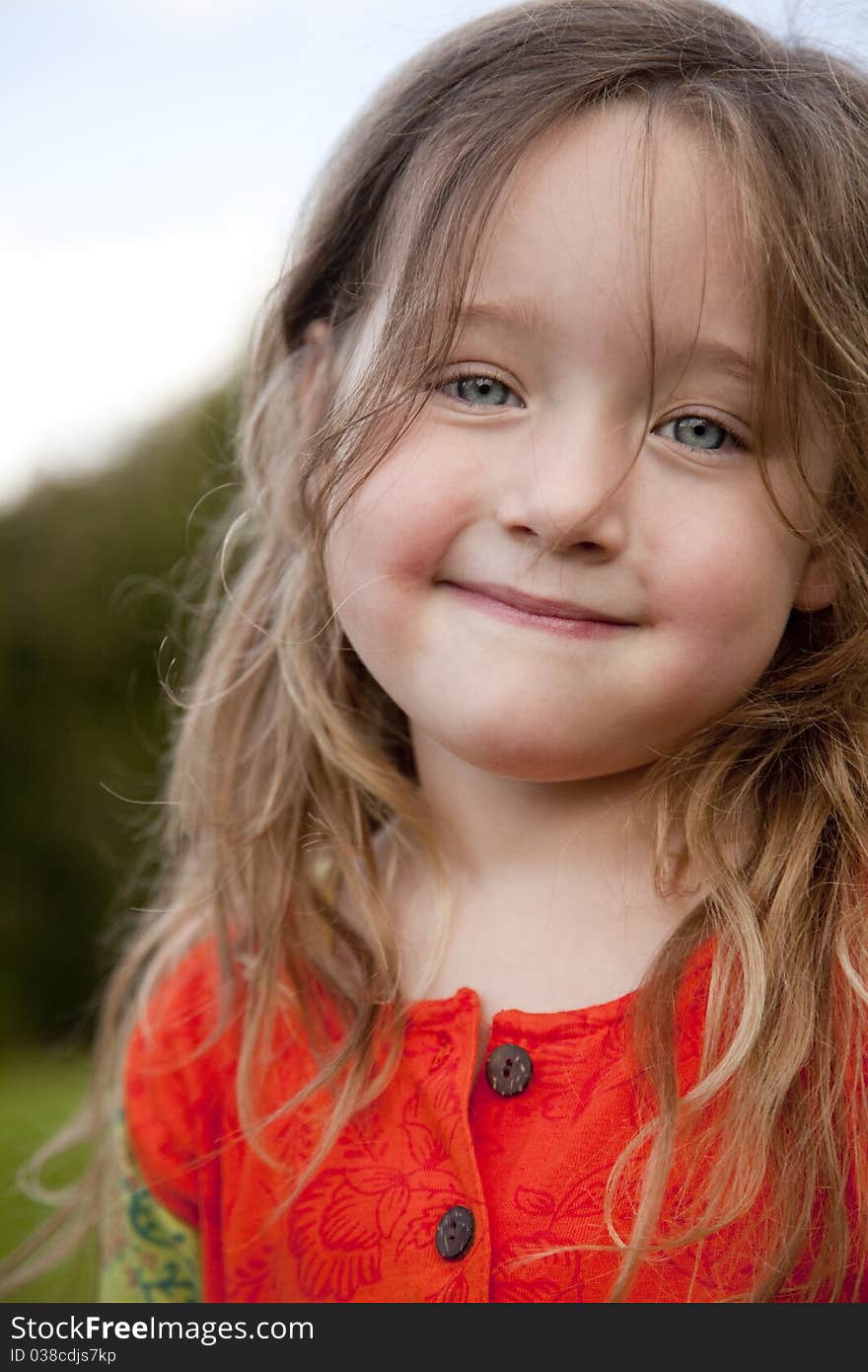 Gorgeous little girl looking straight into camera with a shy smile. Gorgeous little girl looking straight into camera with a shy smile