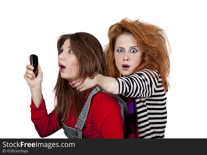 Two funny girls. One of them calling by phone. Studio shot.