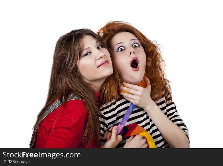 Two funny angry girls. One of them strangle to other. Studio shot.