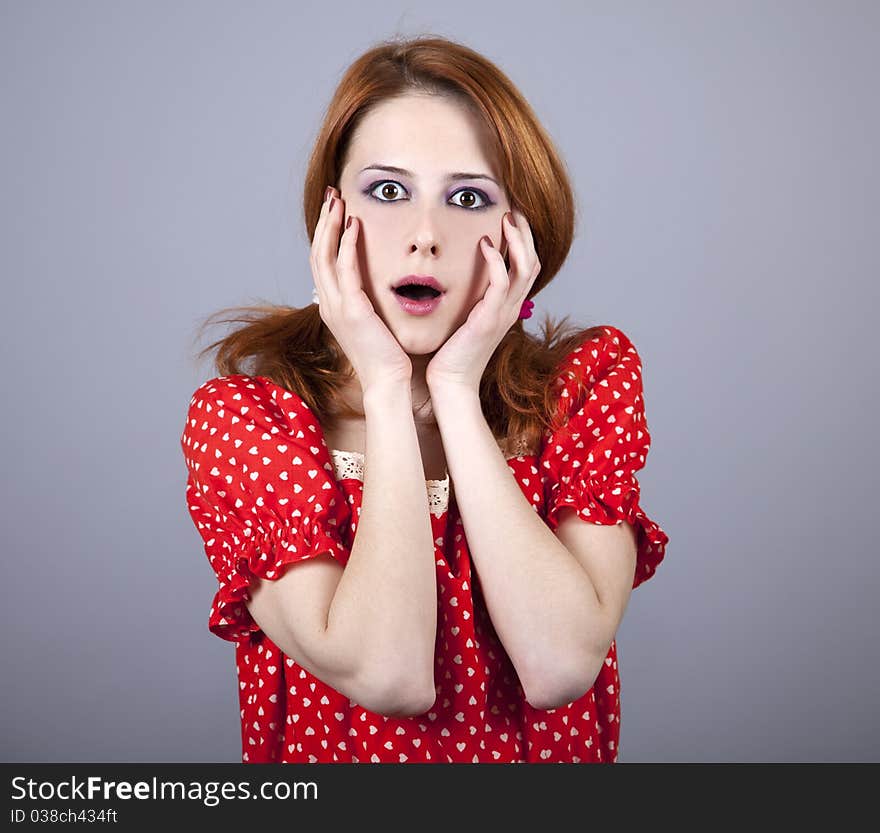 Surprised girl in red. Studio shot.