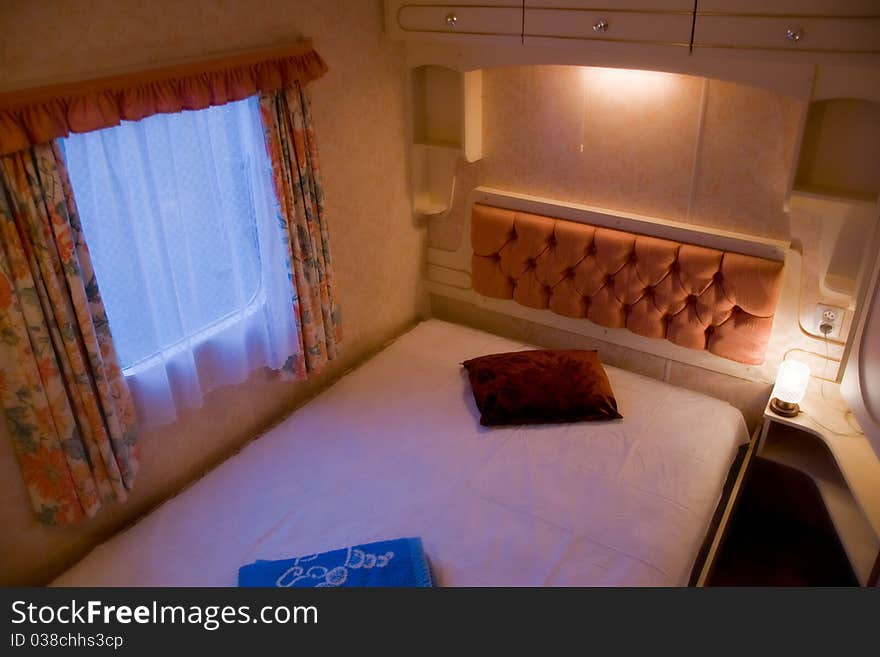 A scene inside of a comfortable, romantic bedroom with nightstands and lamps in luxury mobile home or motor home. A scene inside of a comfortable, romantic bedroom with nightstands and lamps in luxury mobile home or motor home.