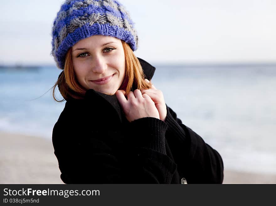 Red-haired girl at the beach. Outdoor shot.